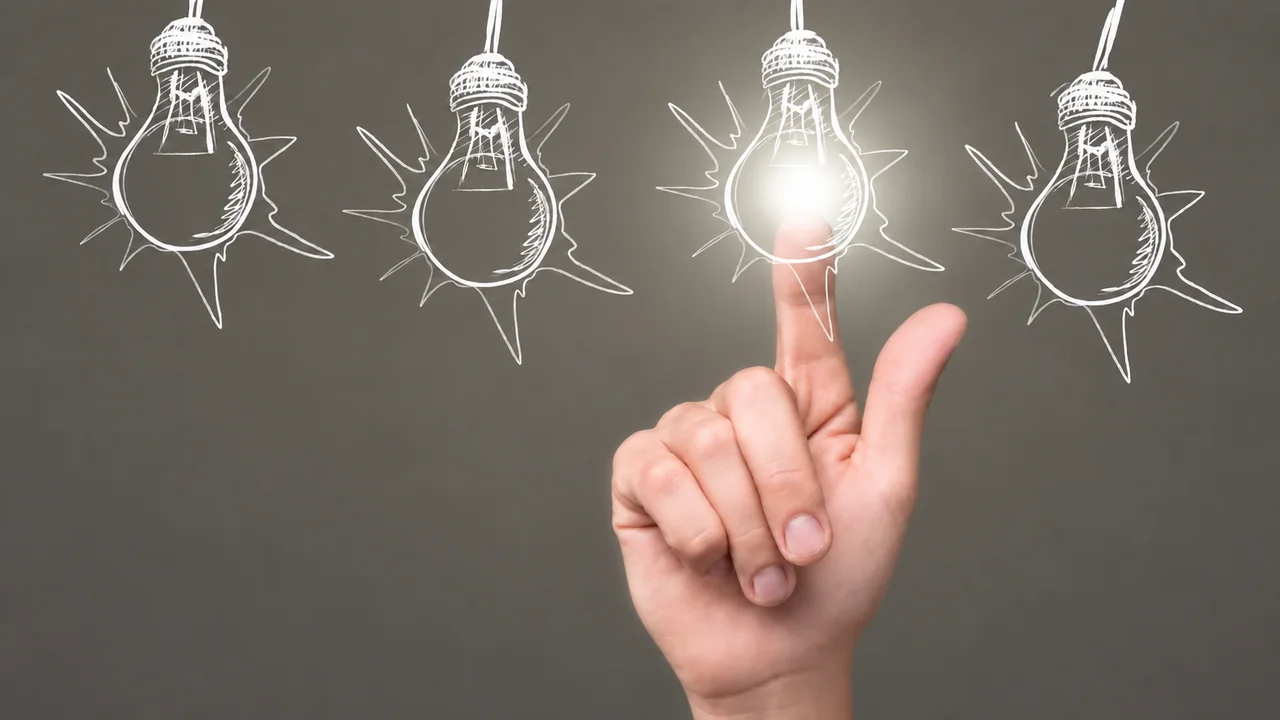 Una mano ilumina una bombilla entre varias ideas